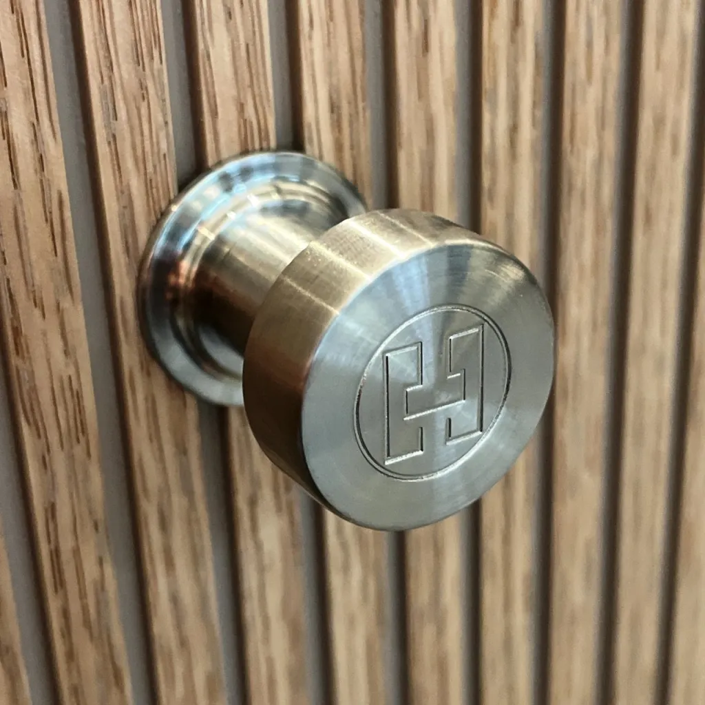 Hassel&Teudt HKN01L - Möbelhandtag med H&T-logotyp, PVD-borstat stål